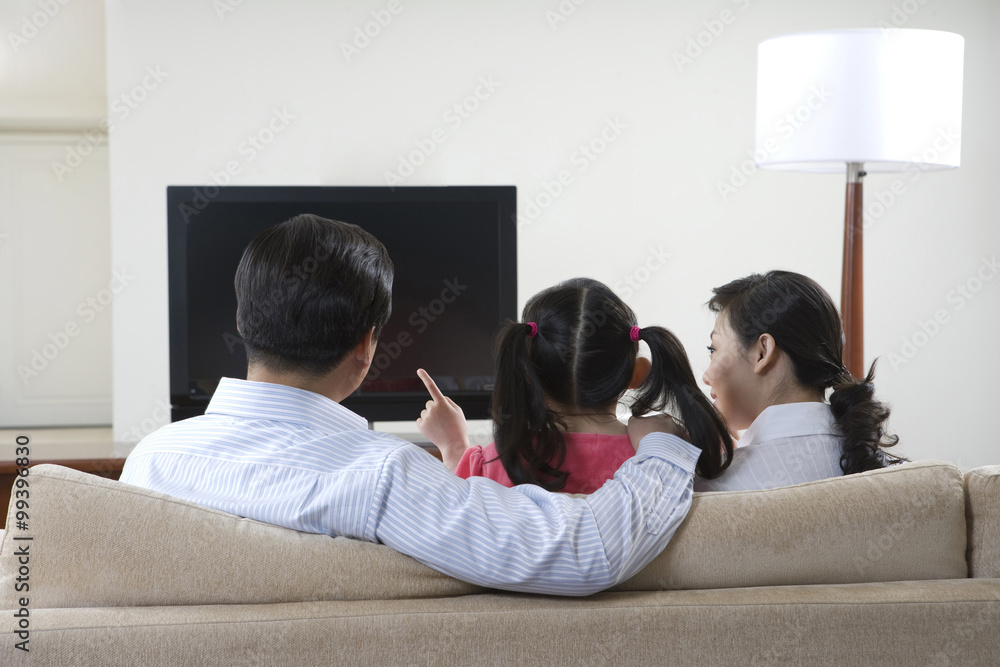 Couple with child in front of widescreen television