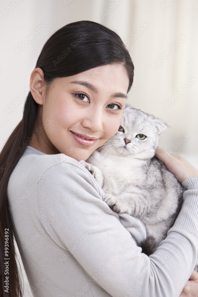 Young woman playing with a Scottish Fold cat