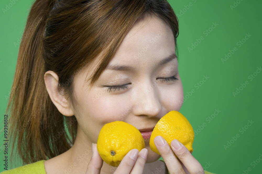 Woman in green smelling a lemon