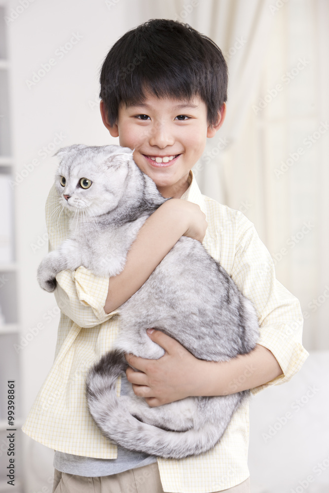 Portrait of little boy carrying cat