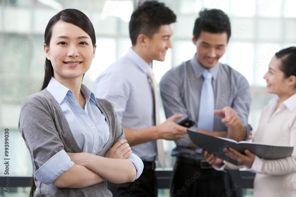 Businesswoman with colleagues in the background