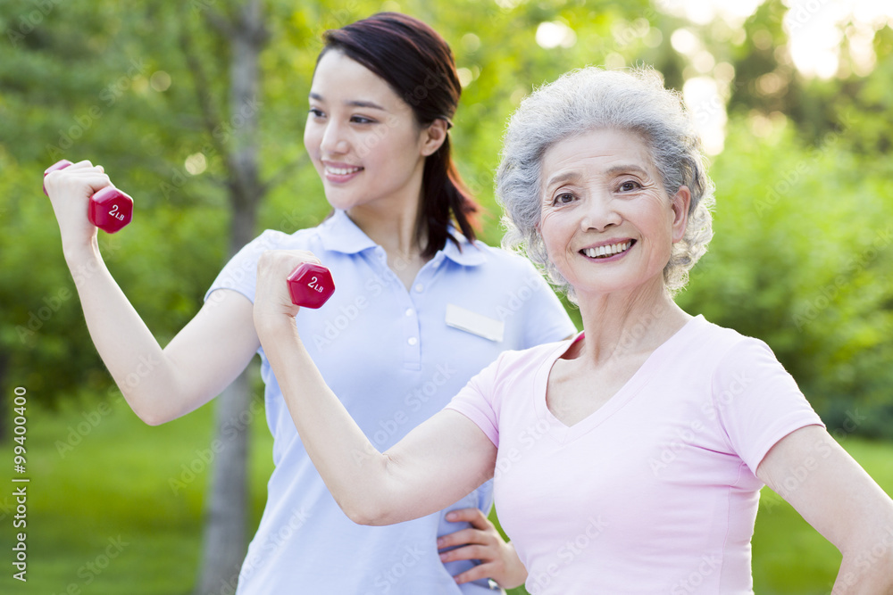 Senior woman exercising with dumbbell in nursing home