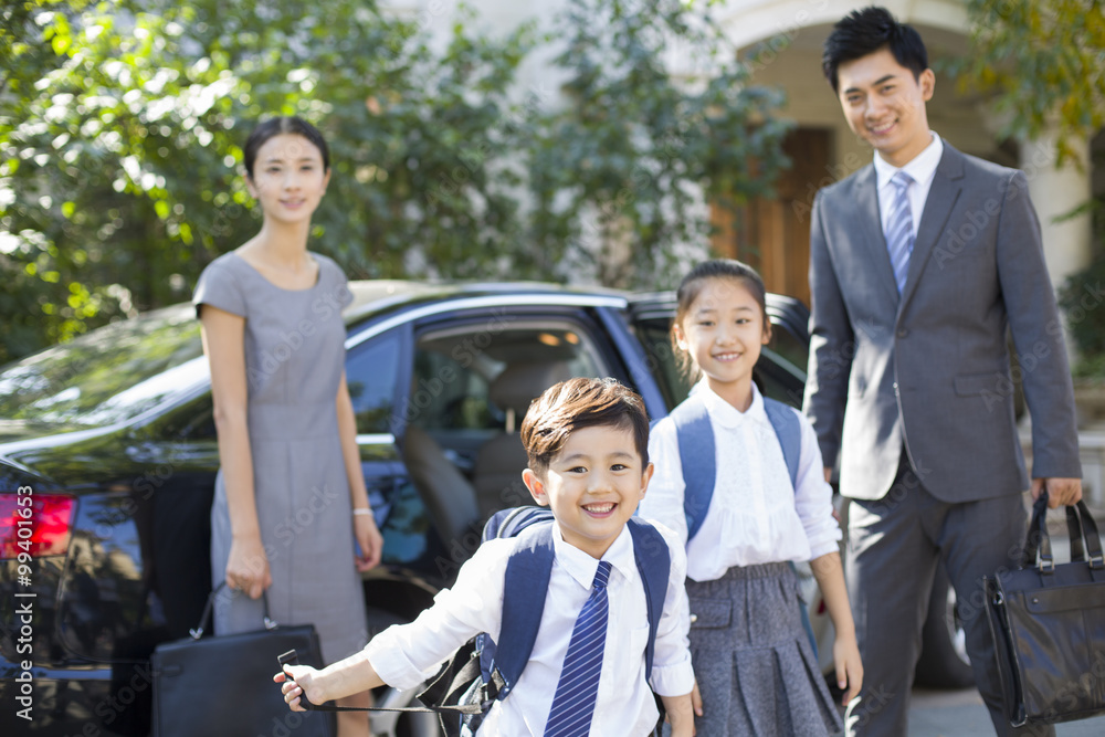 年轻夫妇带着孩子从学校回来