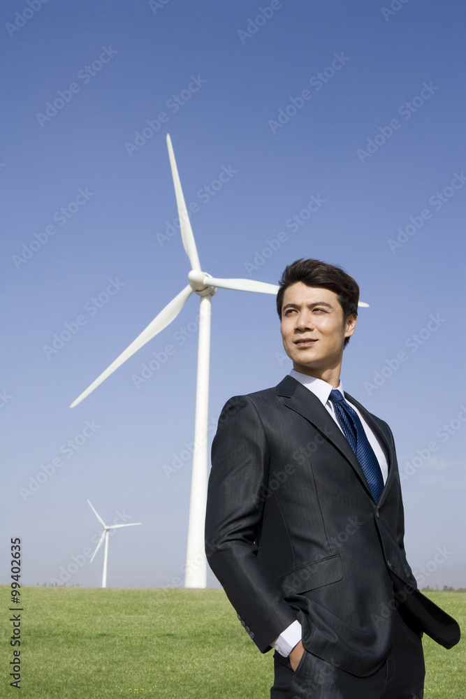 Businessman in front of wind turbine