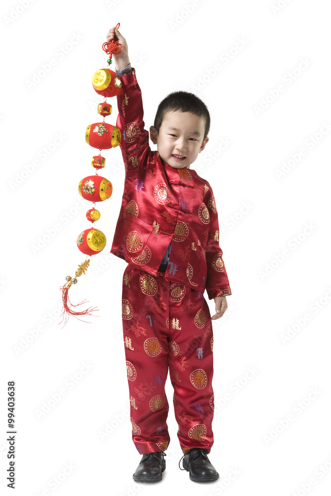 身着中国传统服饰的男孩手持中国新年装饰品