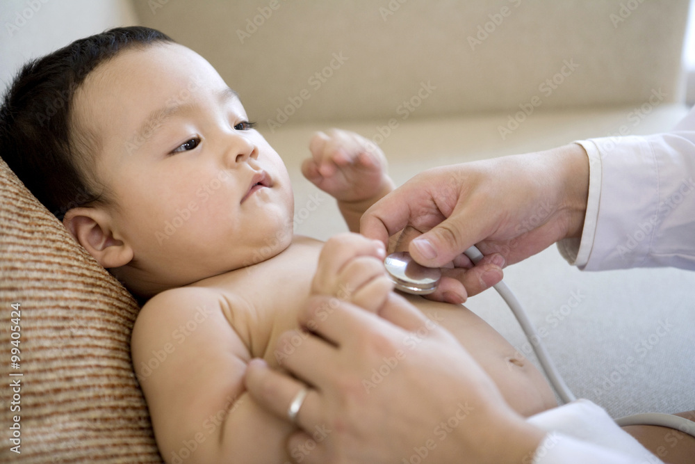 Close up of doctor examining  baby boy with stethoscope