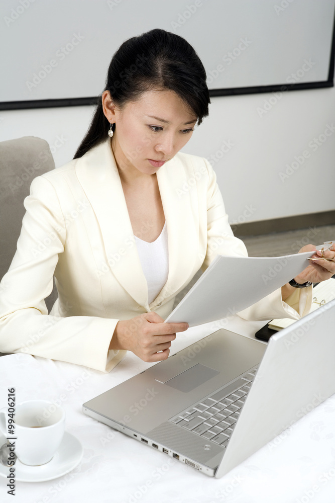 Businesswoman Using Laptop At Dinner Table