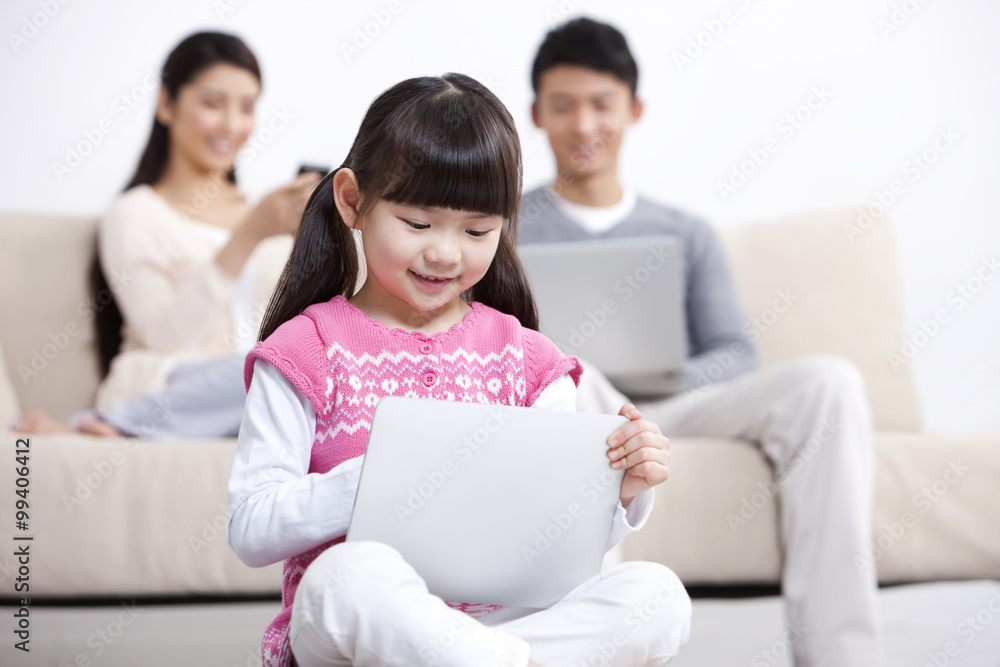 Young family using electronic gadgets in living room