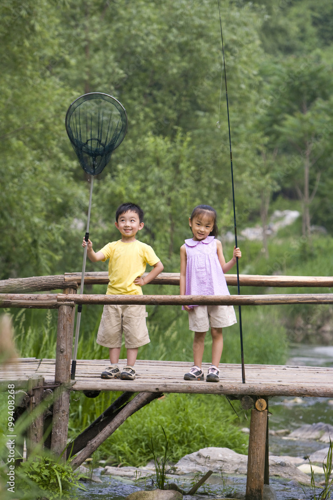 Sibling standing on pier with fishing net