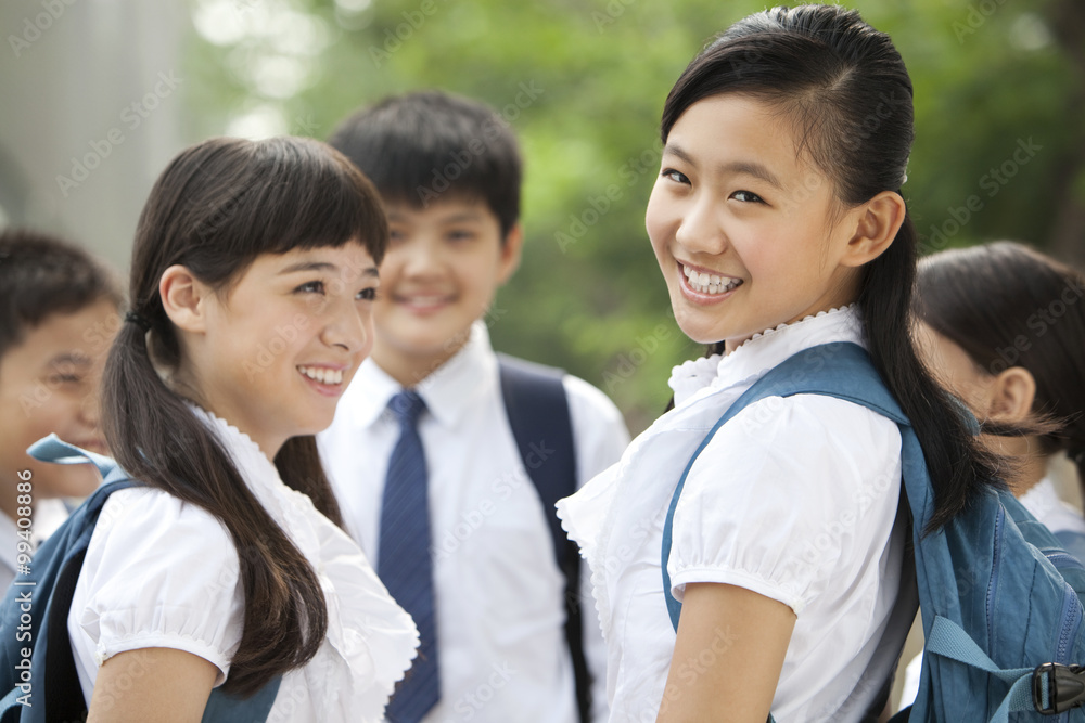 穿着制服的快乐女学生和她的朋友在户外