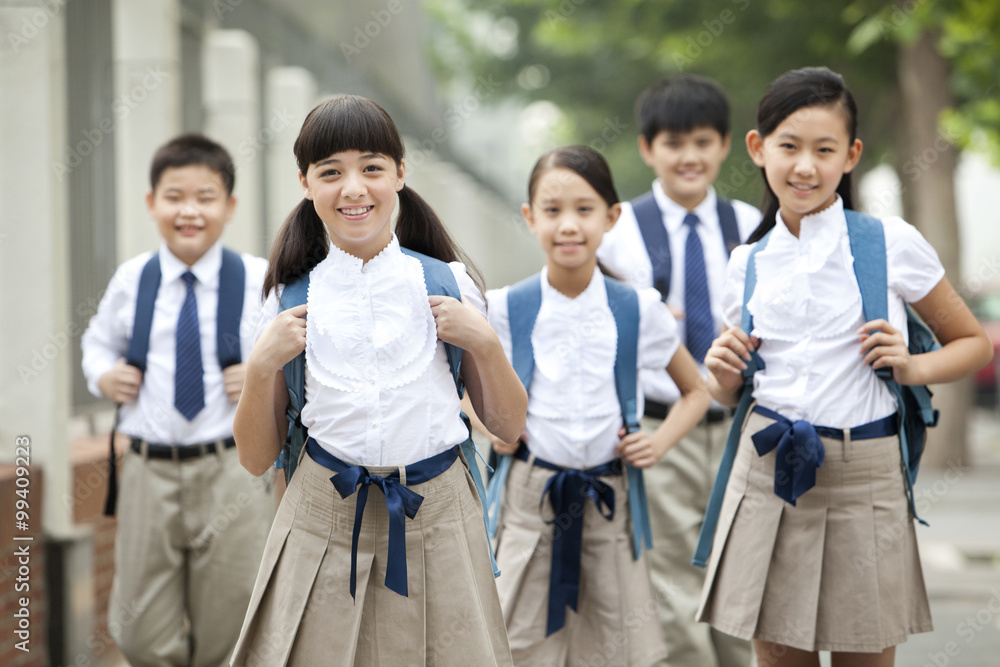 Lovely schoolchildren in uniform on the way to school