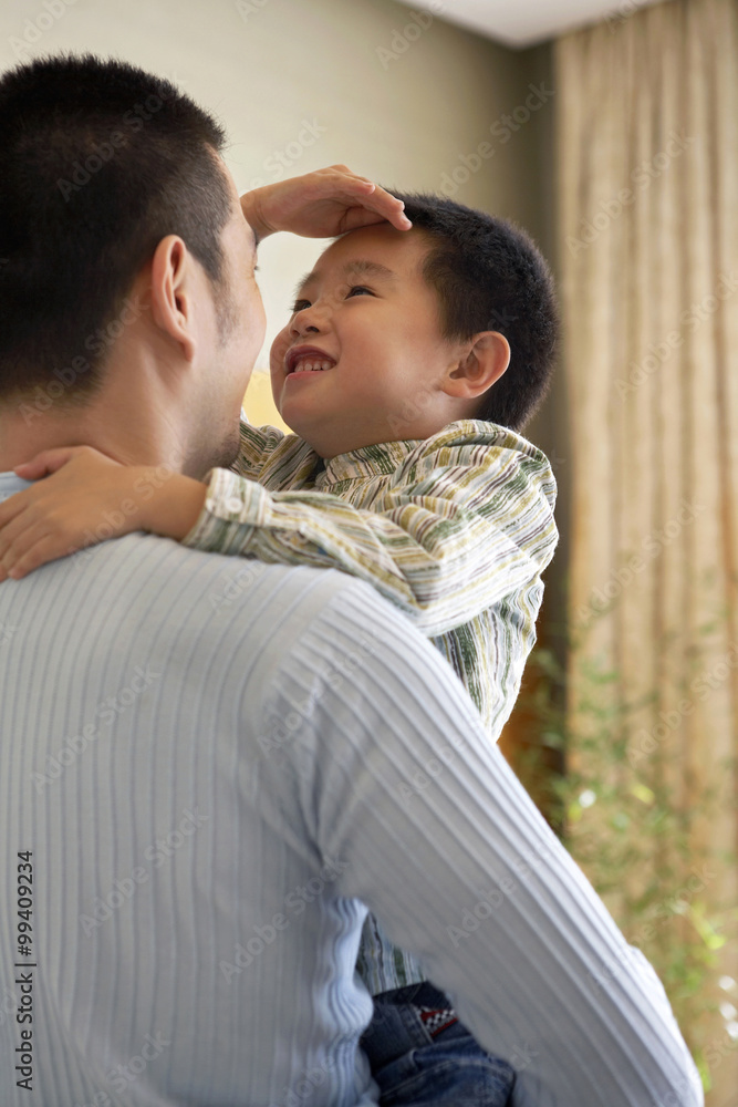 Boy Measuring His Height Against His Father