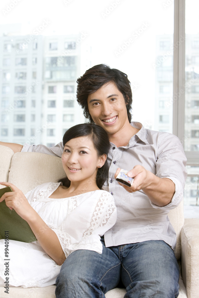 Asian couple cuddling on a sofa