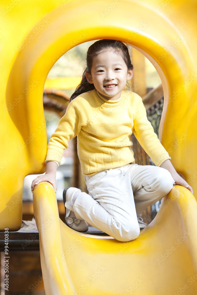 Girl playing on playground slide