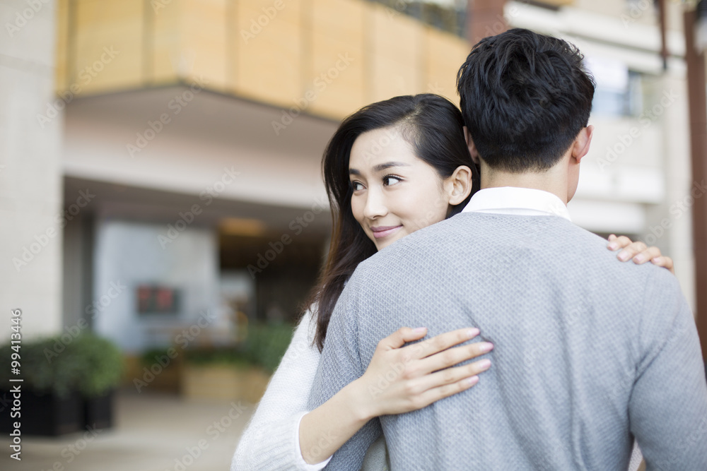 Young couple embracing in shopping mall