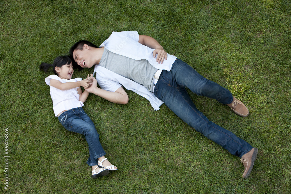 Young Chinese father and daughter on the grass