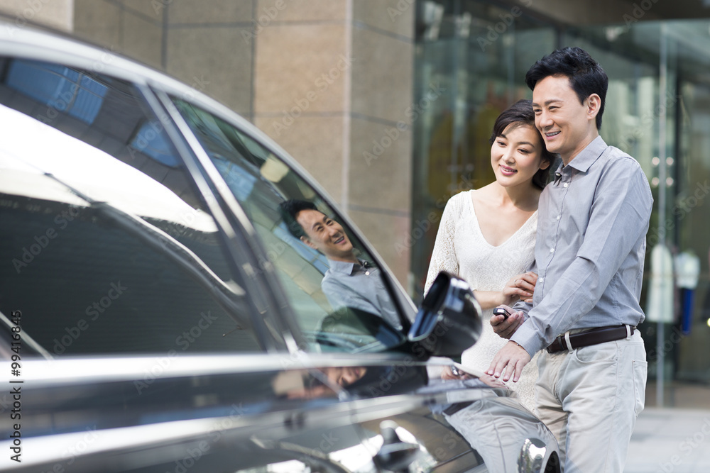 Happy couple with a new car