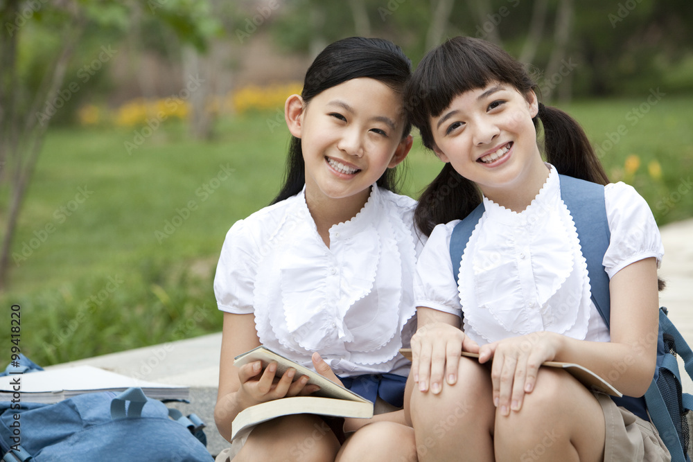 身穿制服的女学生并排坐在台阶上的肖像