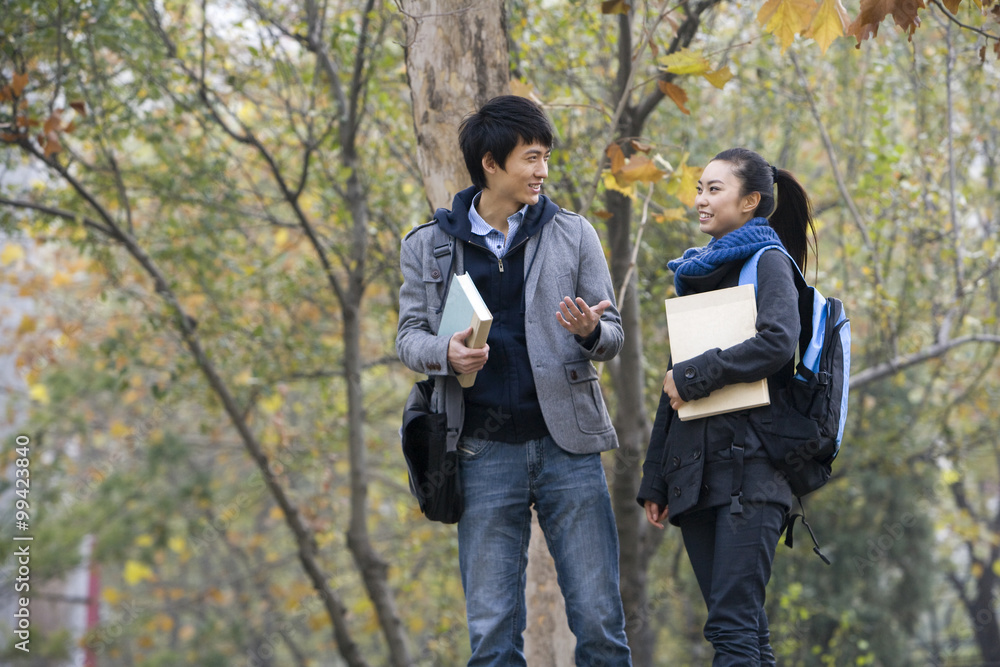 A young man and woman talking together on campus