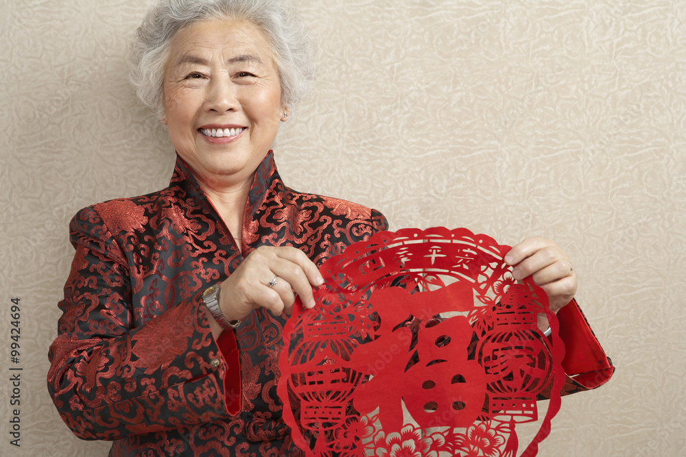 Women Holding Paper Cutting Which Symbolizes Luck