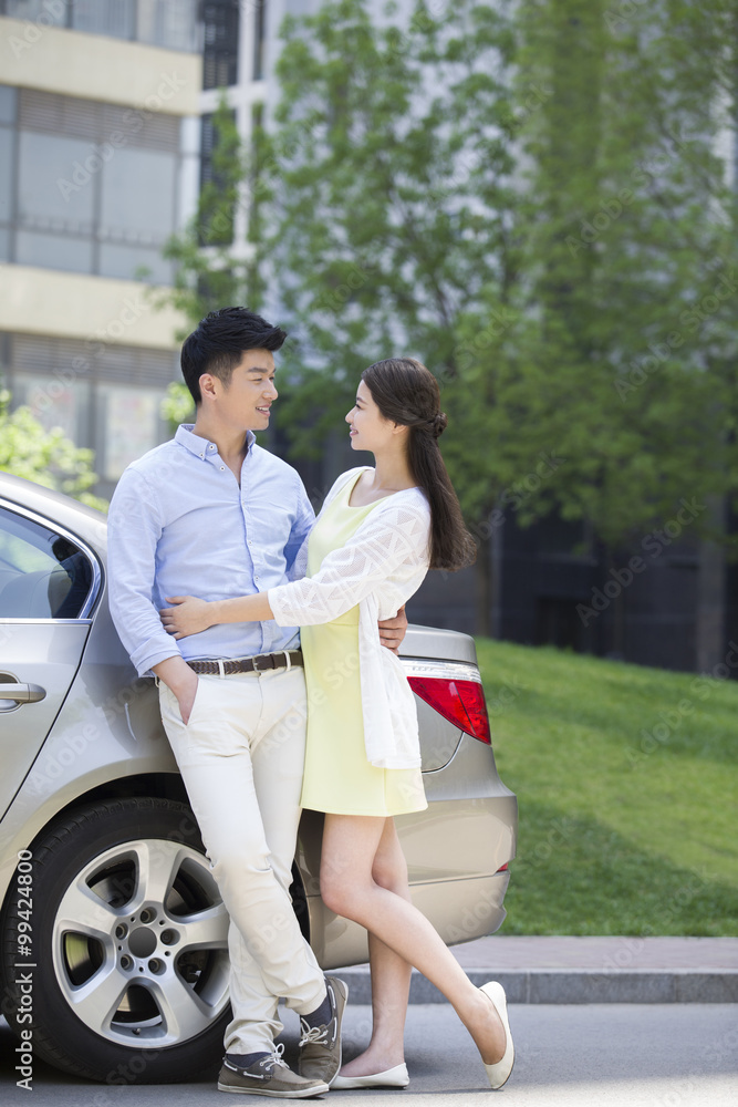 幸福的年轻夫妇和汽车