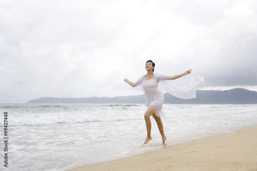 一位年轻女子在海滩上奔跑的肖像