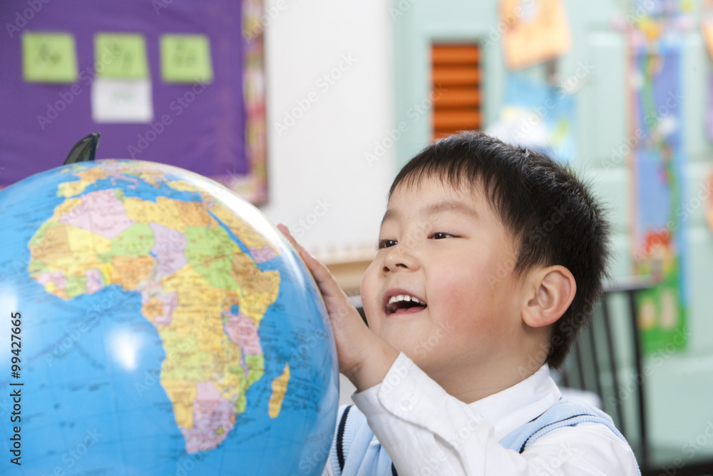 Young student looking at globe