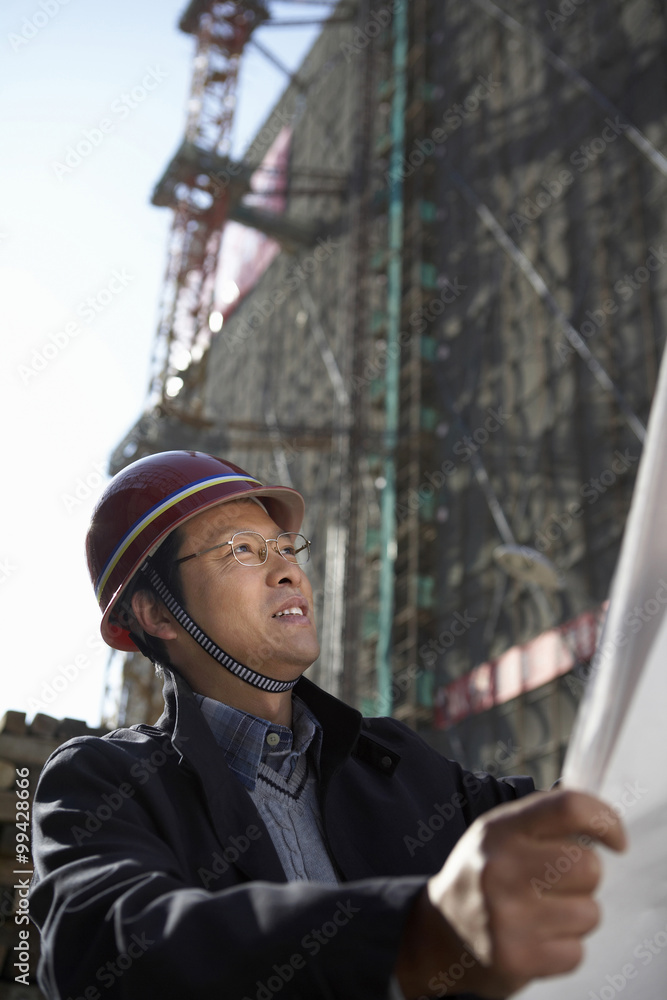 Businessman In Construction Site Wearing Hard Hat