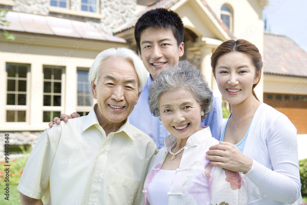 Family of four in front of house