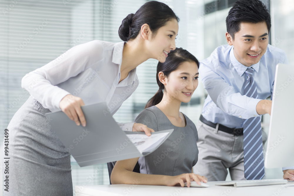 Young business people using computer in office