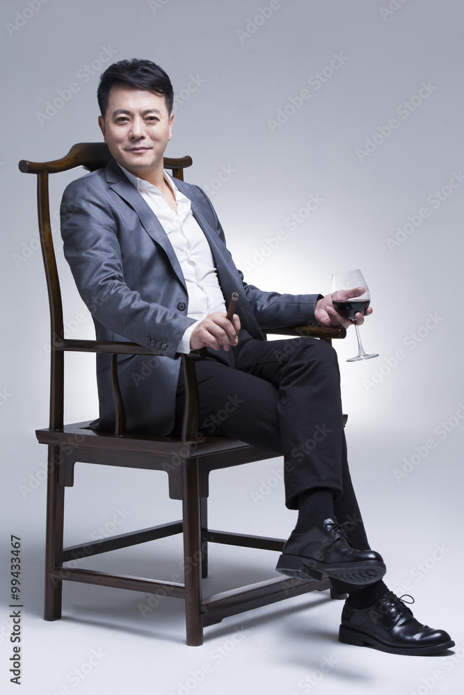 Mature businessman enjoying cigar and wine