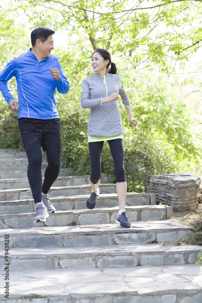 Happy mature couple running in park