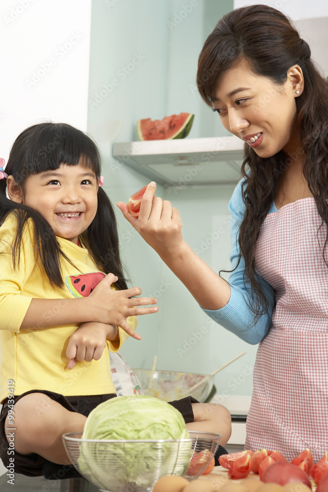 Mother And Daughter Chopping Up Fruit And Vegetables