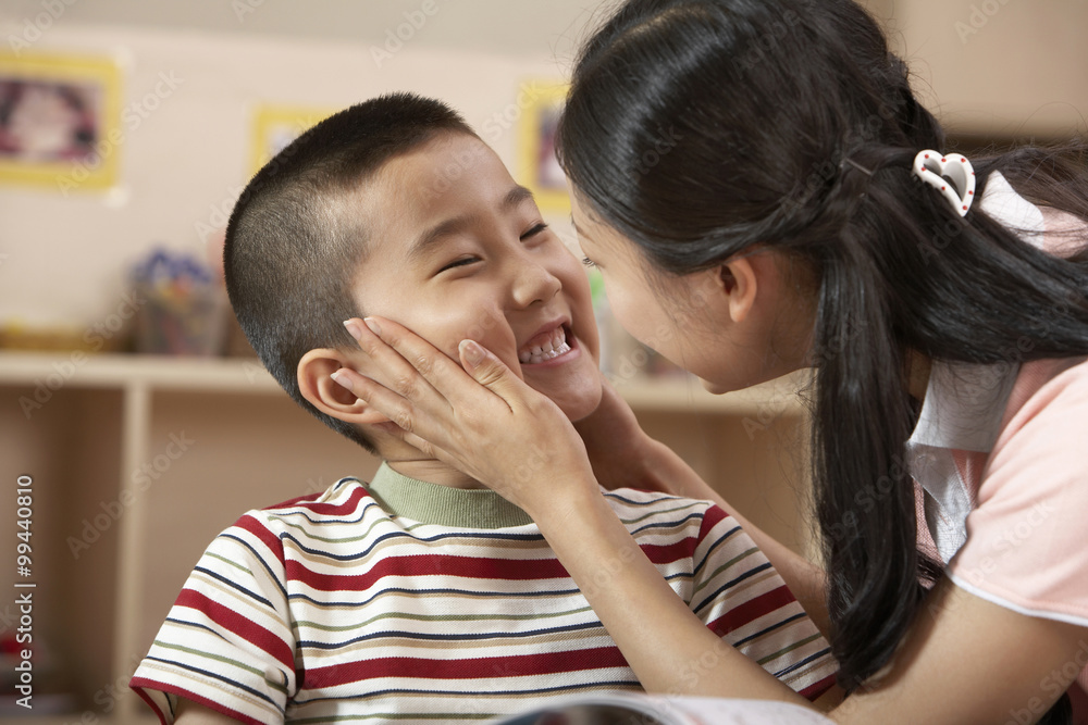 老师和年幼的孩子在读书，互相微笑