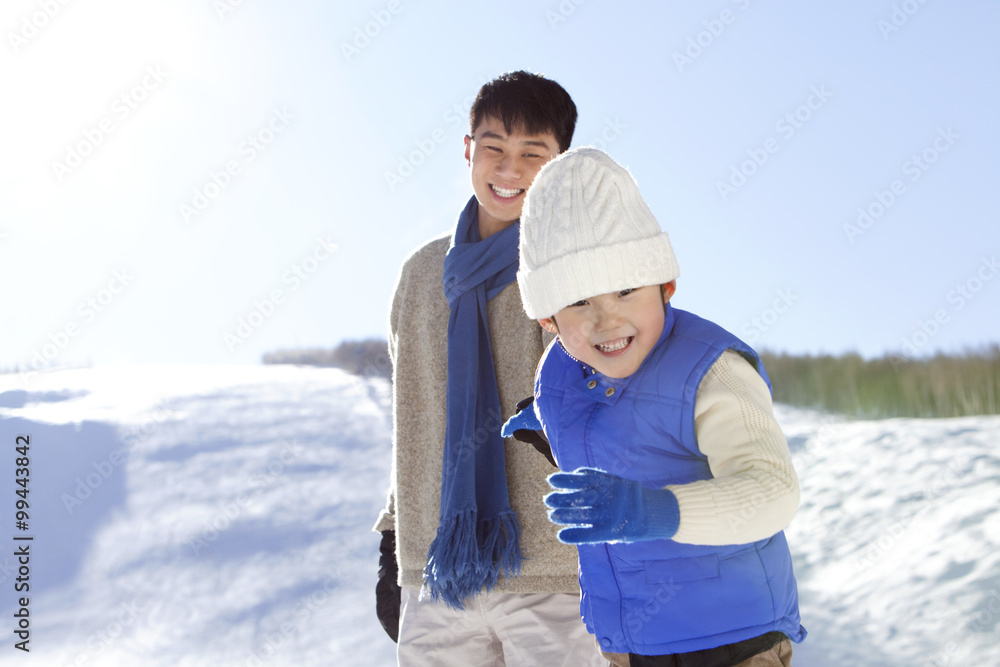 父亲在雪地里和儿子玩耍