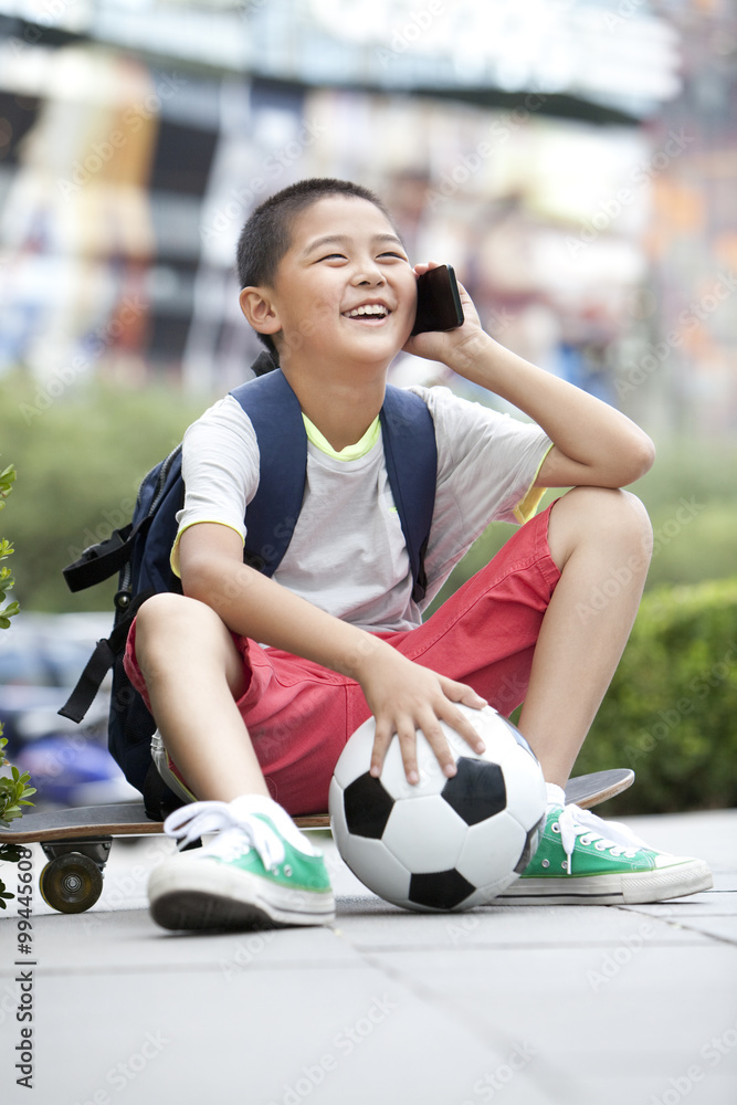 Happy schoolboy on the phone