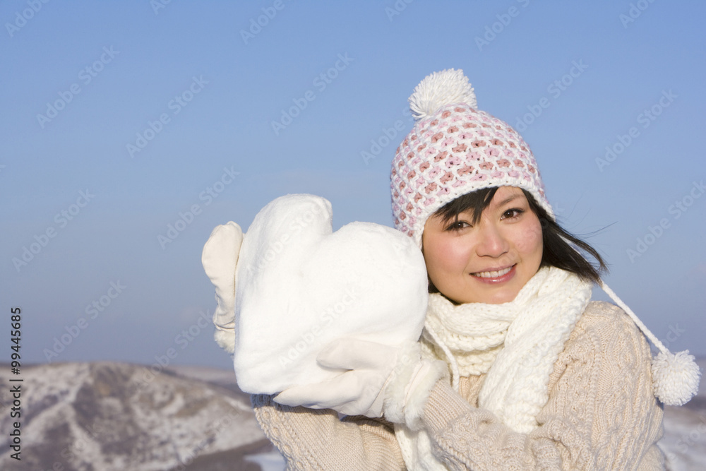 年轻的女人抱着一颗白色的心