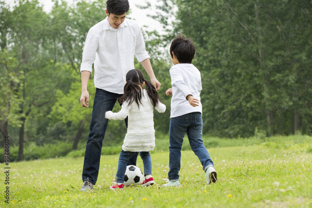 Happy father and children playing football together