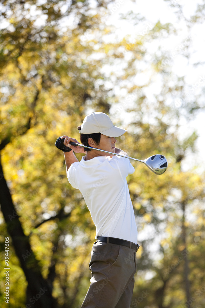 Young Man Taking a Golf Swing