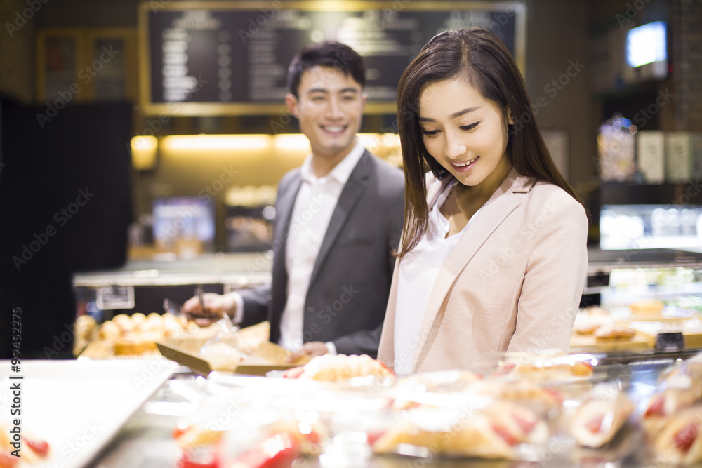 年轻夫妇在面包店挑选面包