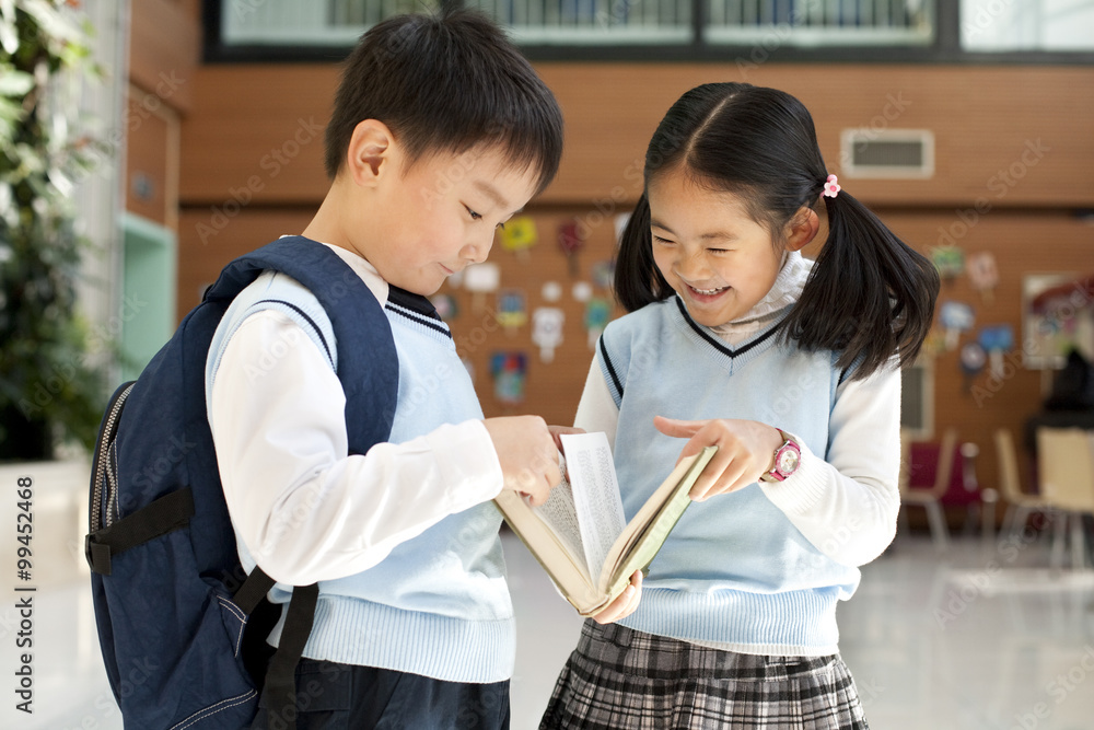 年轻学生挤在一起看书