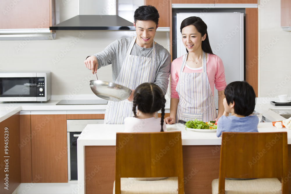 Happy young family cooking in kitchen