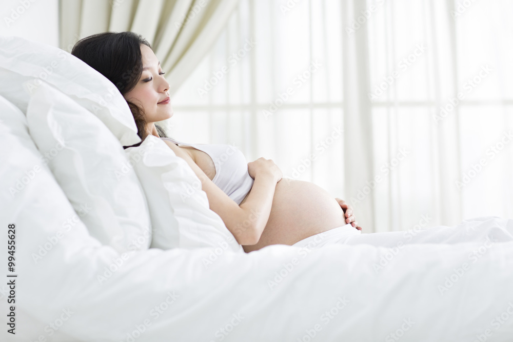 Pregnant woman sleeping in bed