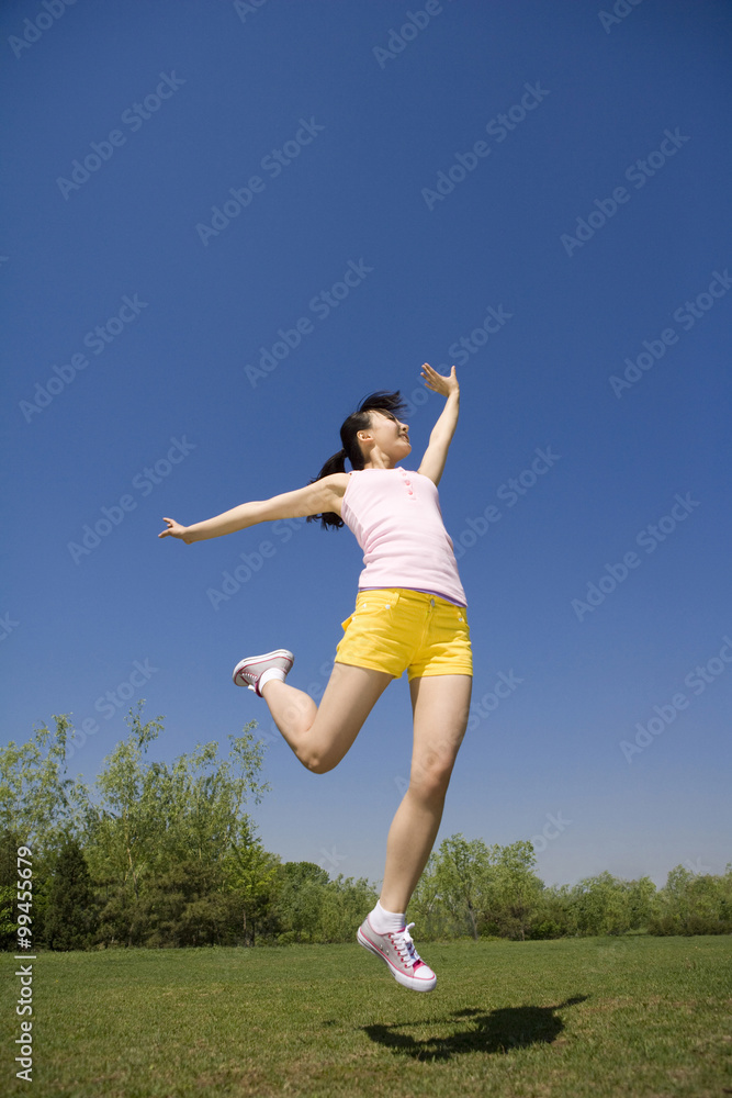 Young woman jumping in the air at the park