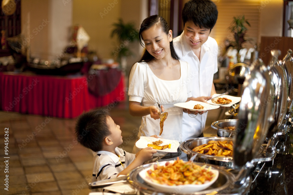 Mother helping her son at a buffet