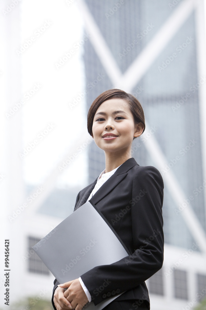 Happy businesswoman with portfolio in hand, Hong Kong