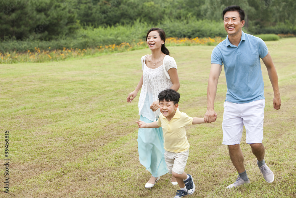 Happy young family running on the lawn