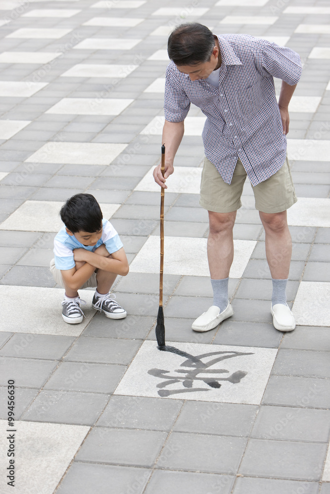 Grandfather teaching grandson calligraphy