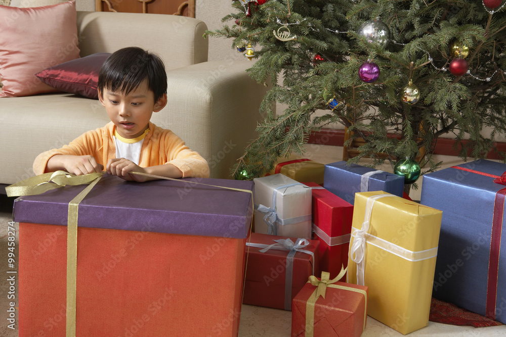 Young Boy Excitedly Opening Christmas Presents