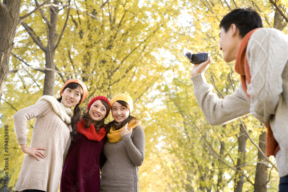 Young Man Filming 3 Friends with a Home Video Camera